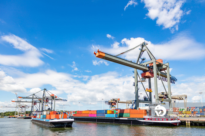 Container ship and logistics. Crane loading a container ship at Rotterdam port