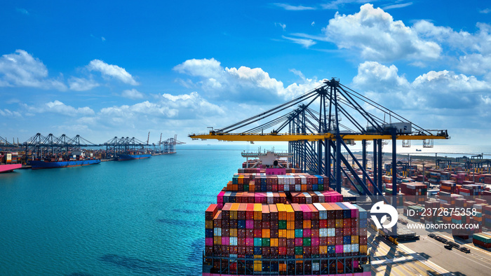 Aerial view of cargo ship and cargo container in harbor.