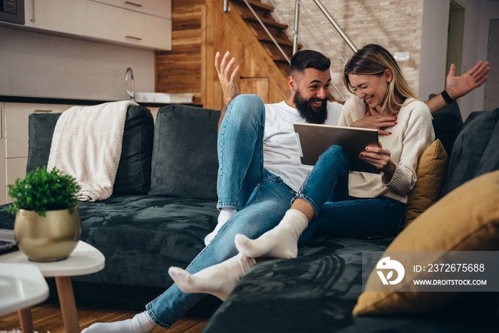 Couple using a digital tablet at home