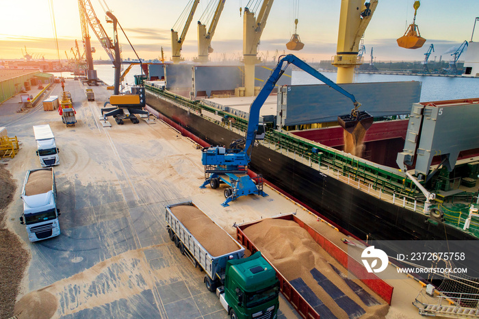 Large international transportation vessel in the port, loading for export in the sea waters.