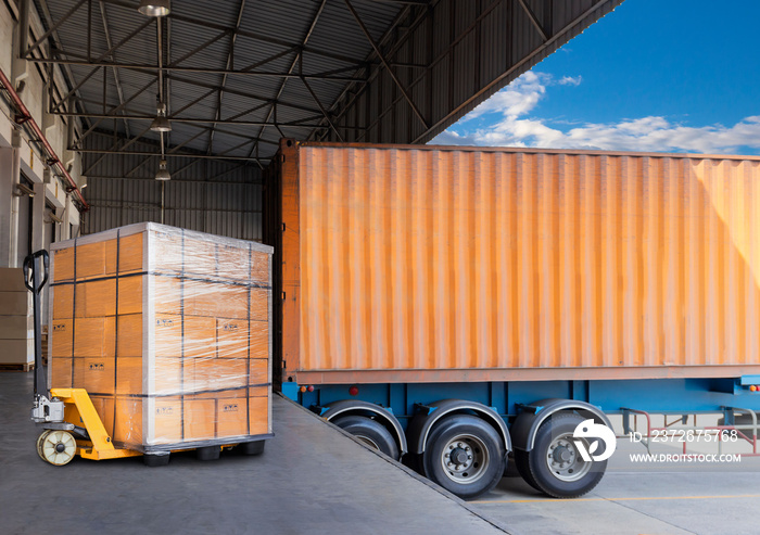 Packaging Boxes Stacked on Pallets Load with Shipping Cargo Container. Delivery Trucks Loading at Do