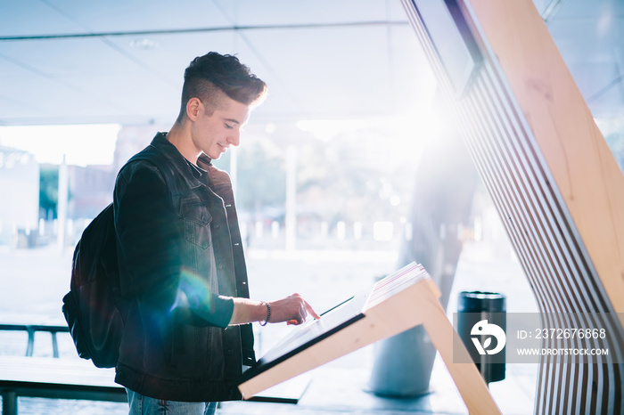 Young man using electronic information stand