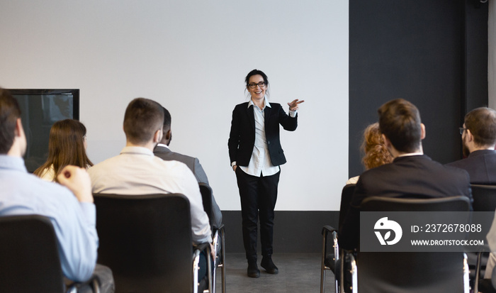 Business training. Female speaker giving lecture to audience