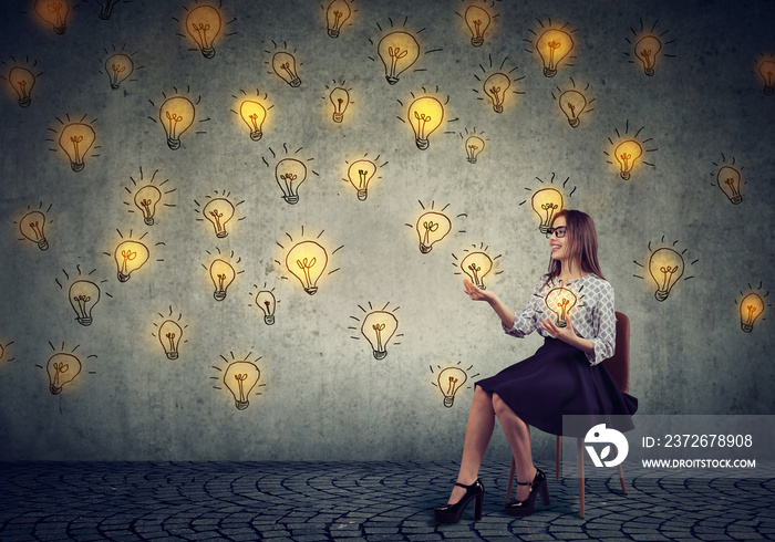 Pretty business woman juggling with light bulbs