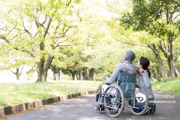 介護イメージ　車椅子シニアとヘルパー後姿