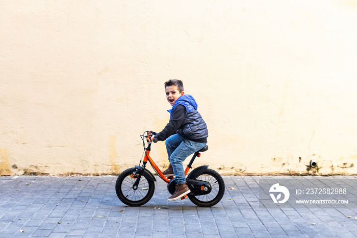 Little kid riding his bicycle on city street