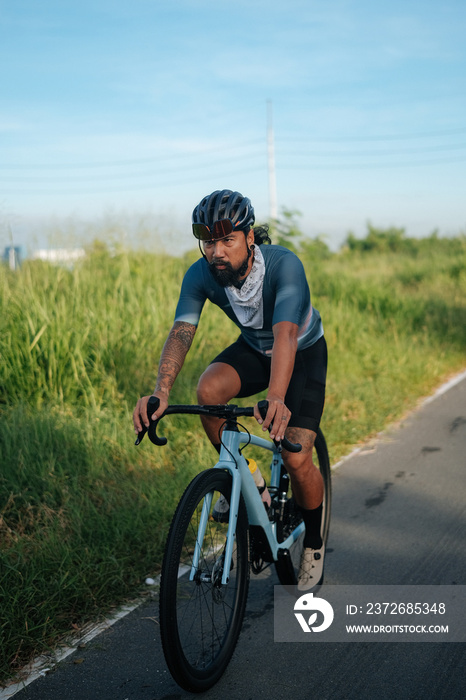 A bearded cyclist riding his gravel bike.