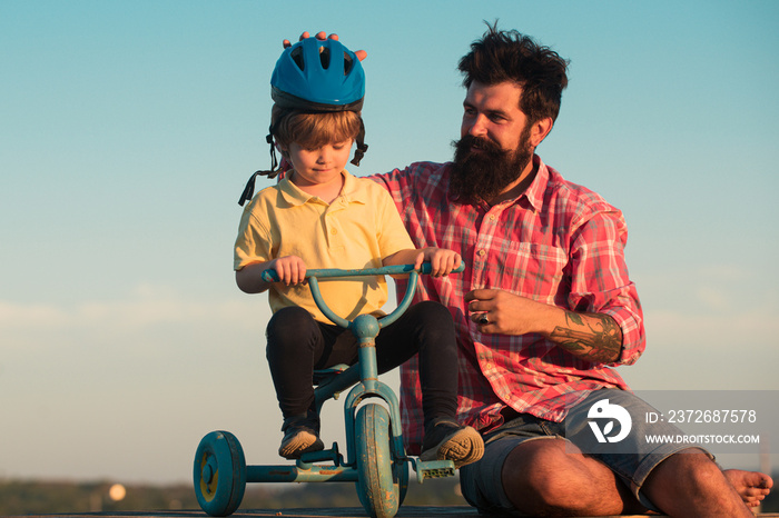 儿童支持和保护。户外骑自行车的快乐父子。家庭、父亲节、亲子节