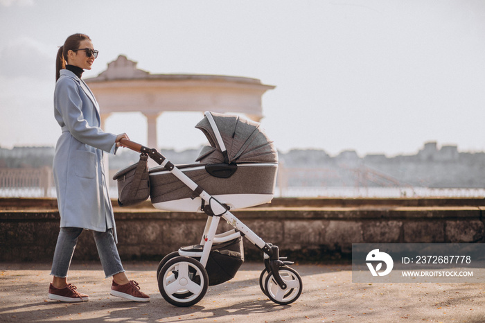 Young asian woman mother, walking with baby stroller in park