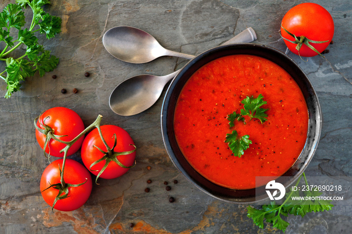 Homemade tomato soup. Above view, table scene on a dark slate background.