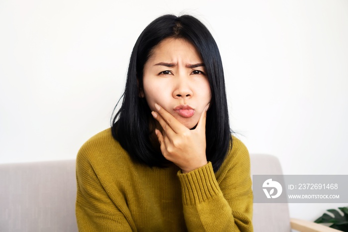 depressed Asian woman having problem with Bells Palsy/Facial Palsy, hand holding her face