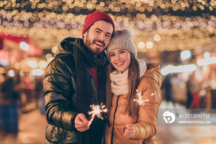 Photo of bonding couple celebrate x-mas christmas lights sparklers under outdoors illumination wear 