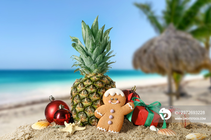 Christmas composition with pineapple on sand at tropical resort