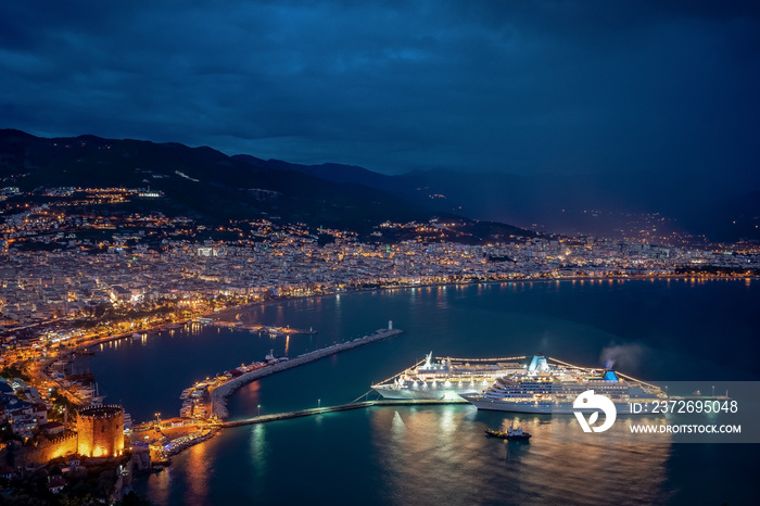 旅游目的地背景。海边壮观的夜晚，城市和游轮灯光