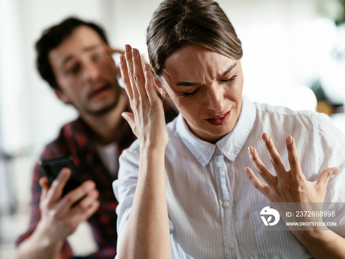 夫妻在家吵架。愤怒的男人对妻子大喊大叫