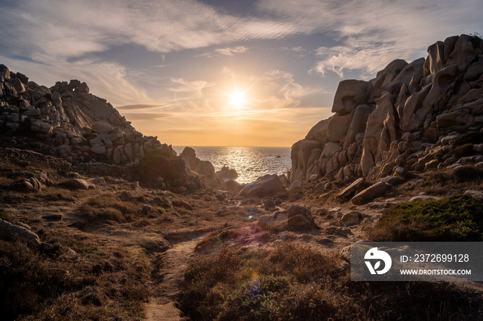 Sunset at Capo Testa. Beautiful sunset over rocks and the ocean. Aurora effect. Orange sky. Rocks su