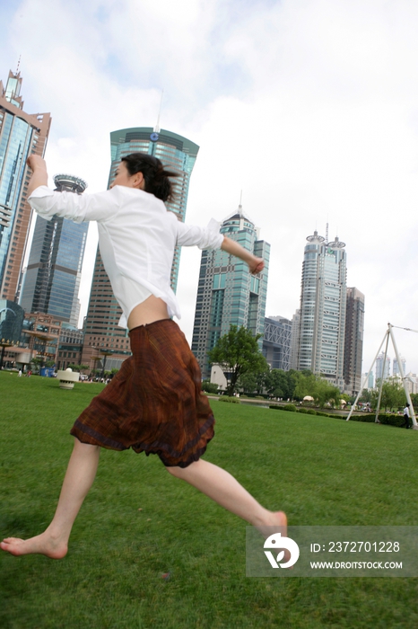 上海浦东写字楼前草坪上一位女商务人士奔跑