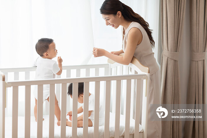 年轻妈妈在家陪龙凤胎宝宝玩耍