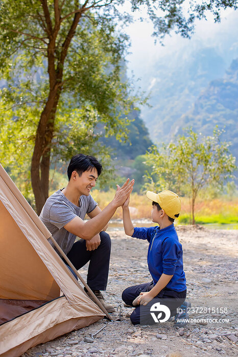 可爱的男孩和爸爸在户外搭露营帐篷