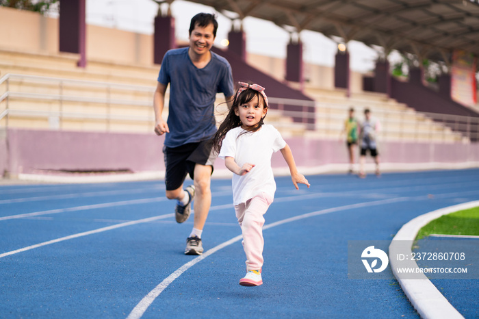 亚洲小女儿和父亲一起在体育场跑步，户外活动的概念，s