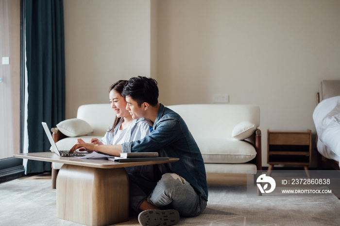 Young Asian couple at home using computer