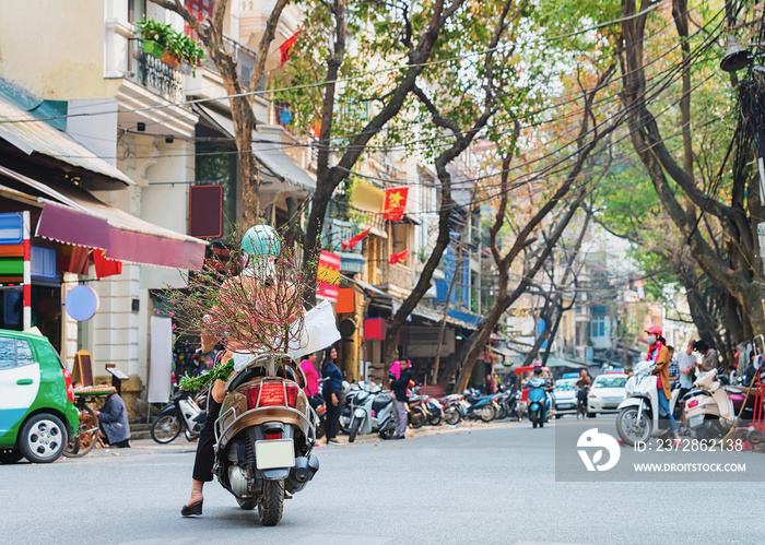 People on scooters at busy street in Hanoi Vietnam