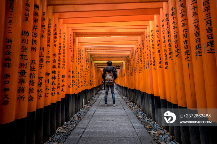 A walking path leads through a tunnel of torii gates at Fushimi Inari Shrine,An important Shinto shr