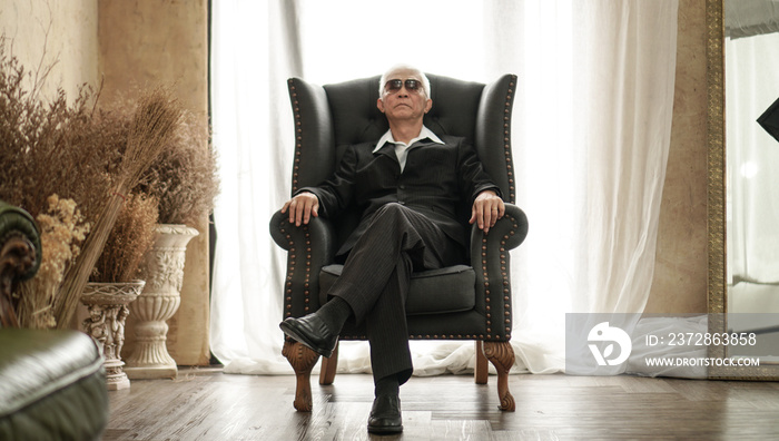 亚洲高级男士，英俊西装，坐在富人昂贵的房子里