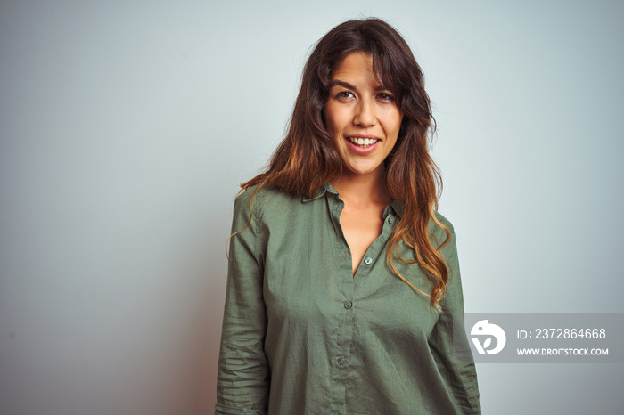 Young beautiful woman wearing green shirt standing over grey isolated background looking away to sid