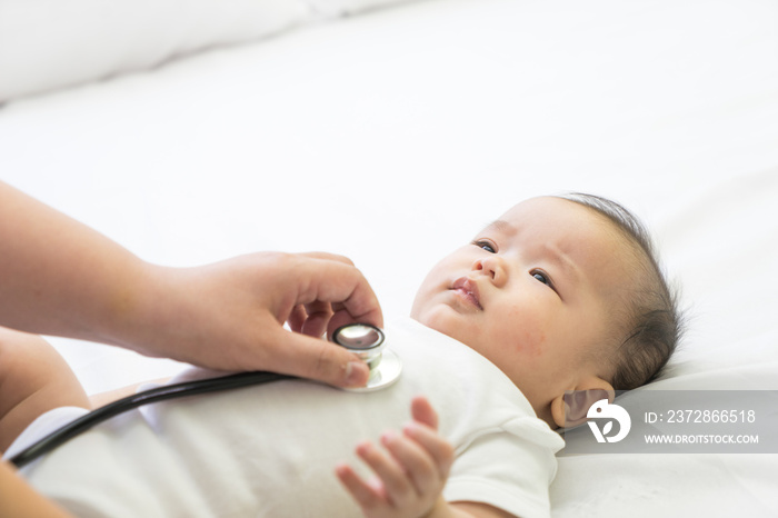 Doctor exams Asian newborn baby with stethoscope in the hospital