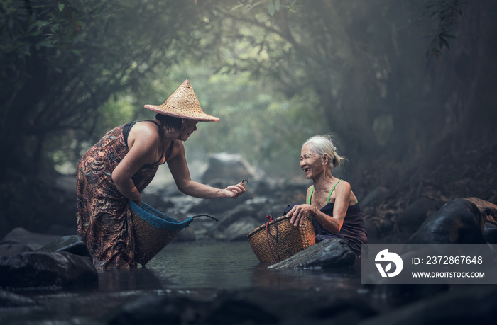 在小溪里工作的亚洲老妇