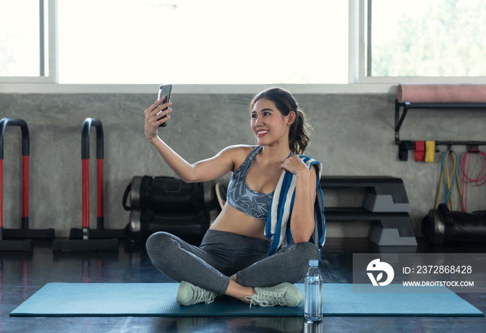 Young asian attractive smiling active fitness in gym and taking a selfie.