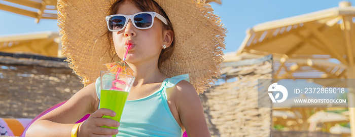 A child at the sea drinks a cocktail. Selective focus.