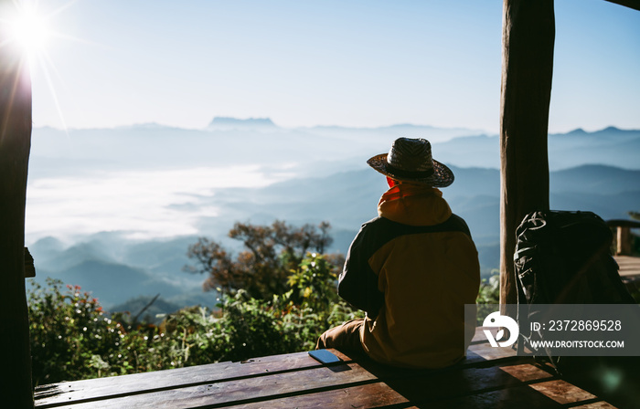 Young man traveler with phone while enjoying beautiful tropical sunrise in Thailand. travel concept.