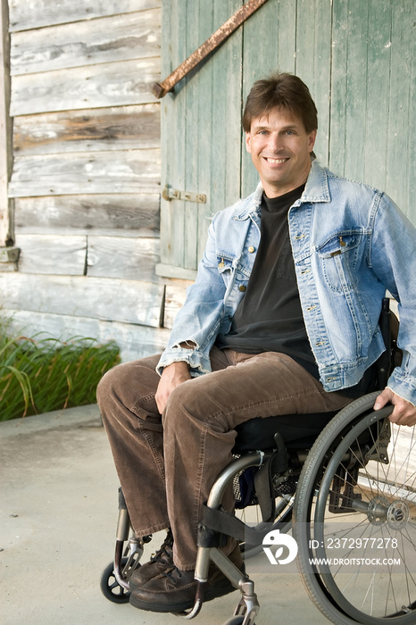 残疾人坐在轮椅上，微笑着
