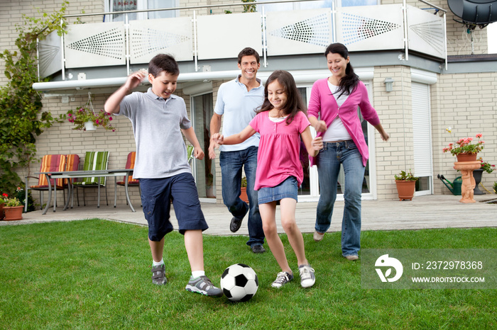 幸福的一家人在后院踢足球