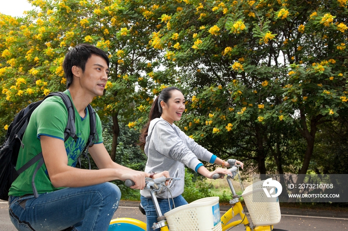 年轻大学生在校园里骑车