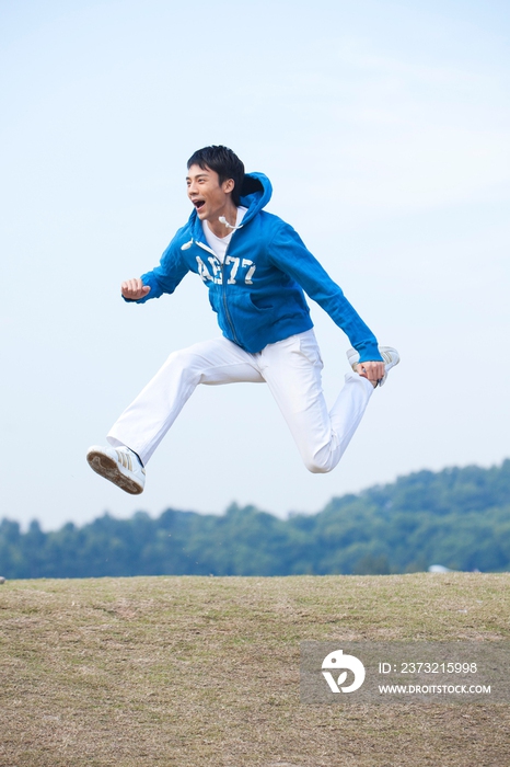 年轻男人在草地上跳跃