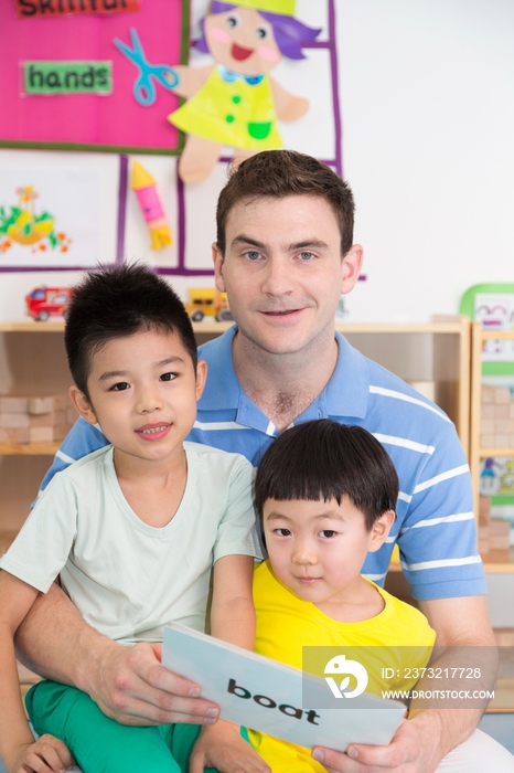 幼儿园外教男老师教儿童读英文卡片