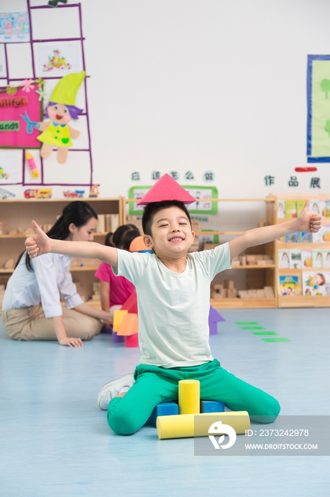 幼儿园儿童坐在地板上玩彩色积木