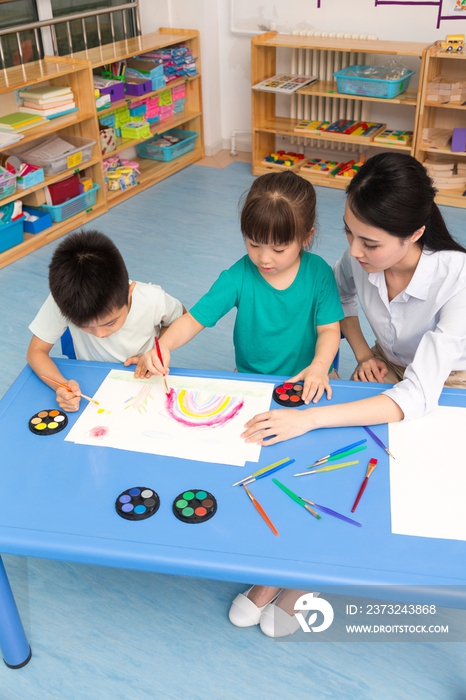 幼儿园女老师辅导儿童画画