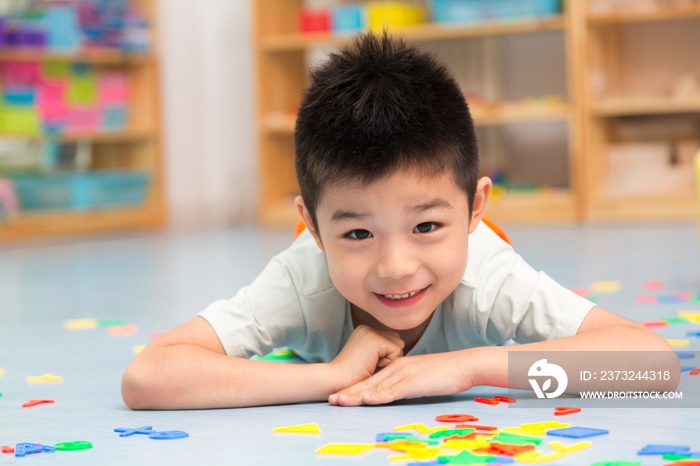 幼儿园儿童趴地板上玩玩具