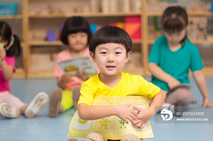 幼儿园儿童坐在地板上看故事书