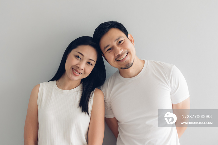 Happy couple lover in white t-shirt and grey background.