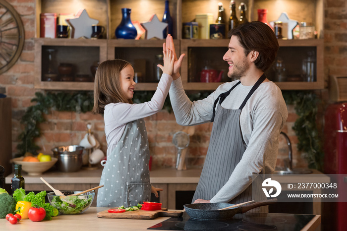 Happy Little Girl Giving High Five To Father After Preparing Lunch Together