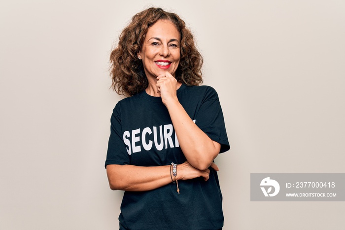 Middle age beautiful guard woman wearing security t-shirt uniform over white background smiling looking confident at the camera with crossed arms and hand on chin. Thinking positive.