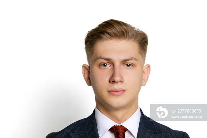 Close-up portrait of handsome young businessman, student, diplomat looking at camera isolated on white studio background. Human emotions, facial expression concept.