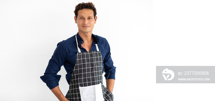 Portrait of smiling young hispanic man in apron looking at camera isolated on white background