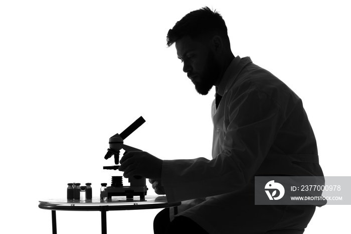 Silhouette of male scientist working with microscope on white background