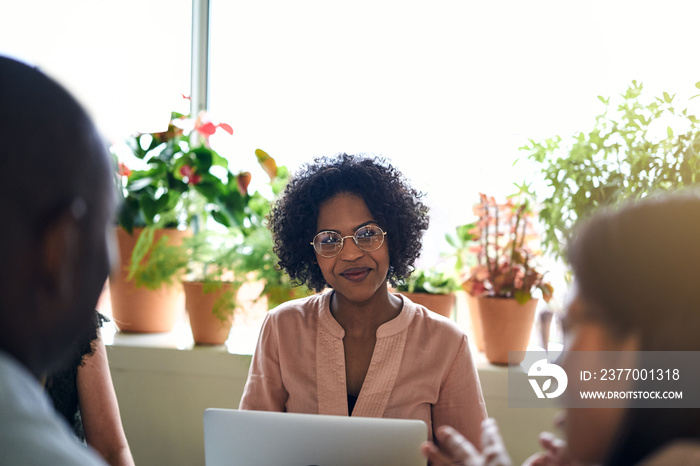 Smiling African businesswoman meeting with colleagues in an offi